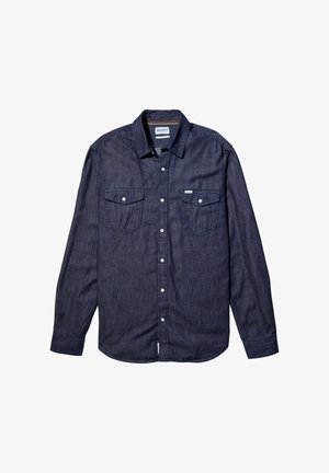 Donkerblauwe denim shirt met lange mouwen, een puntige kraag, twee borstzakken met kleppen en witte knopen. Glad textuur.