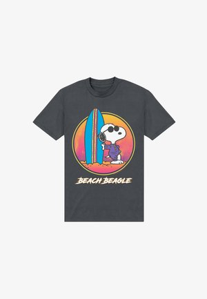 Maglietta grigio scuro con Snoopy che indossa occhiali da sole e outfit viola, appoggiato su una tavola da surf blu, sfondo al tramonto, testo "Beach Beagle."