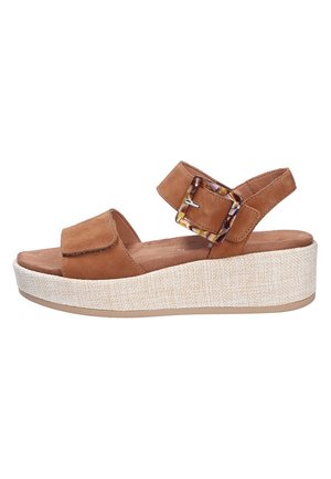 Sandalo platform in suede marrone con cinturino regolabile alla caviglia e fibbia grande in tartaruga, suola zeppa beige texturizzata.