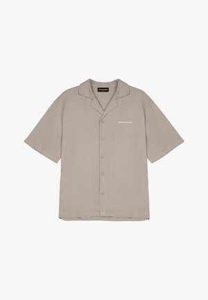 Rövid ujjú, gombos ing világos bézs anyagból. Klasszikus gallérral rendelkezik, és egy finom "PEgador" mintázat található a bal mellen.