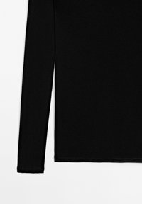 Black long-sleeve fitted shirt on a white background, showing left sleeve and lower torso section with visible stitching hem.
