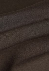 Tissu marron foncé tissé serré avec des plis doux créant des ombres et des reflets subtils à la surface.