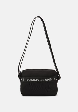 Borsa a tracolla nera con fondo in rete testurizzata, dotata di una tracolla nera regolabile e un logo bianco "TOMMY JEANS" ben visibile.