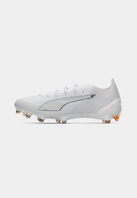 Botte de football blanche avec un upper texturé, des accents argentés et six crampons. Présente un design épuré et un système de laçage pour un ajustement sécurisé.