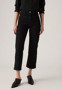 Jeans neri a vita alta con taglio dritto, caratterizzati da cuciture tonali, una consistenza di denim sostanziosa e chiusura frontale con bottone.