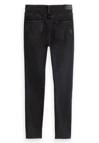 Jeans skinny negros con una textura suave, que cuentan con dos bolsillos traseros y un dobladillo deshilachado. La cinturilla incluye una etiqueta con el logo sutil.