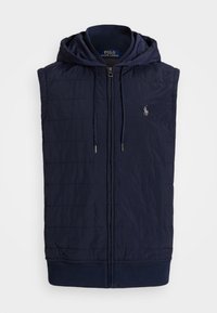 Mörkblå ärmlös pufferväst med dragkedja framtill, huva, ribbad fåll och subtil randig textur. Logotyp på vänster bröst.