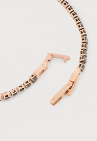 Rózsaarany karkötő, téglalap alakú láncszemekkel, fekete kő díszítéssel és kapoccsal. Simább textúrájú, polírozott felülettel.