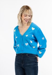 Cardigan blu fluffy con scollo a V, chiusura a bottoni e applicazioni a forma di cuore multicolori. Tessuto testurizzato, maniche ampie.
