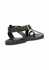 Black flat sandal featuring a wide strap with gold hardware and an open toe design. Made of smooth synthetic material with a flat sole.
