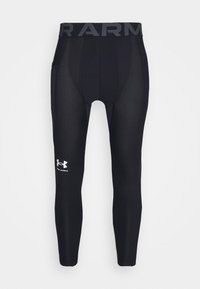Sorte kompressionsleggings med en bred grå talje, der har "ARMOUR" branding; glat tekstur; accentueret med et hvidt logo på nederste del af benet.