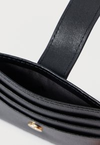 Geantă din imitatie de piele neagră, cu o textură netedă, având un singur mânere, multiple compartimente și detalii din metal auriu.