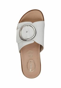 White slide sandal made of smooth synthetic material. Features a wide band with a circular silver accent. Flat sole with subtle cushioning.