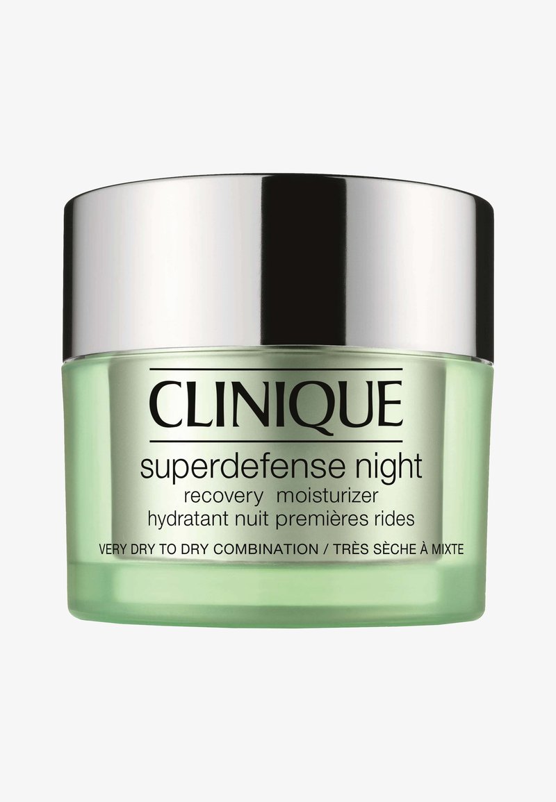 Vihreä lasipurkki hopeisella kannella. Etiketissä lukee "Clinique Superdefense Night Recovery Moisturizer" mustalla. Jäykkyys näyttää sileältä.