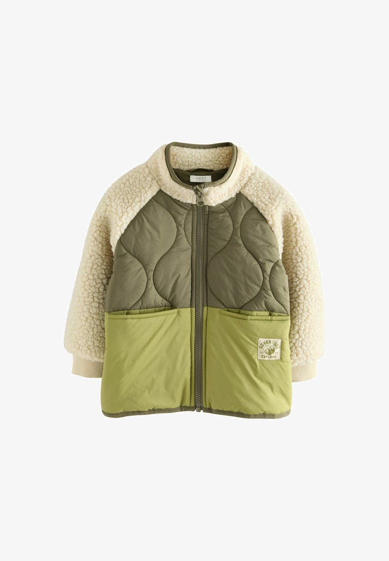 Grüne gesteppte Jacke mit cremefarbenen Fleece-Ärmeln, zwei Fronttaschen und einem Reißverschluss. Enthält ein Logo-Patch auf der unteren linken Seite.