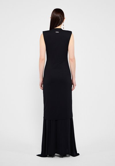 Black sleeveless dress with a fitted bodice and a flowy bottom. Smooth fabric, long silhouette, features a subtle logo detail at the back.