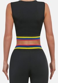 Czarny krótki top na ramiączkach z kolorowym wielopasmowym paskiem w talii w czerwone, niebieskie i żółte akcenty. Gładka tekstura tkaniny.