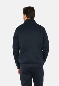 Maglione a collo alto blu navy, realizzato in un materiale morbido, con polsini e fondo a coste, design minimalista senza fantasie.