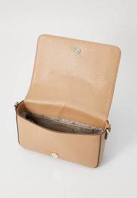 Borsa a tracolla color beige chiaro con una superficie in pelle liscia, chiusura a scatto e un unico scomparto interno con una fodera a motivo.