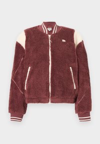 Μπουφάν bomber από φλις σε μπορντό χρώμα με λευκές λεπτομέρειες στους ώμους, εμπρόσθιο φερμουάρ, τσέπες με φερμουάρ και ριγωτές ριμπ μανσέτες και γιακά.