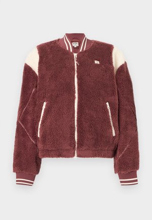 Μπουφάν bomber από φλις σε μπορντό χρώμα με λευκές λεπτομέρειες στους ώμους, εμπρόσθιο φερμουάρ, τσέπες με φερμουάρ και ριγωτές ριμπ μανσέτες και γιακά.