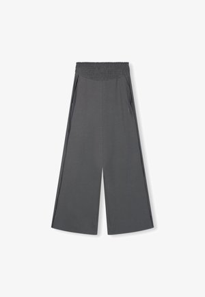 Graue, weite Hosen aus weichem Material. Mit elastischem Bund, seitlichen Taschen und kontrastierenden, vertikalen Streifen an den Seiten.