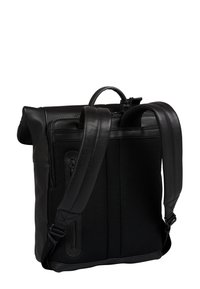 Sac à dos en cuir noir avec un panneau texturé, des bretelles rembourrées et un compartiment zipé. Le design est minimaliste et fonctionnel.