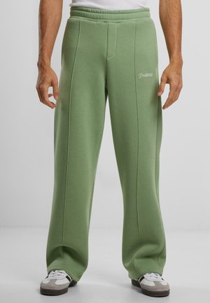 Grønne joggebukser laget av mykt materiale med en avslappet passform. Har forhåndsømmer og brodert "Forbudt"-logo i hvitt.