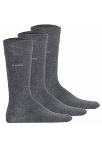 Calzini grigi in mistura di cotone, con polsini a coste, una texture liscia e aree rinforzate sulla punta e sul tallone; tre paia esposti insieme.