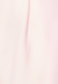 Telas de un suave color rosa pálido con un sutil pliegue vertical en el centro, creando una suave sombra sobre la superficie lisa.
