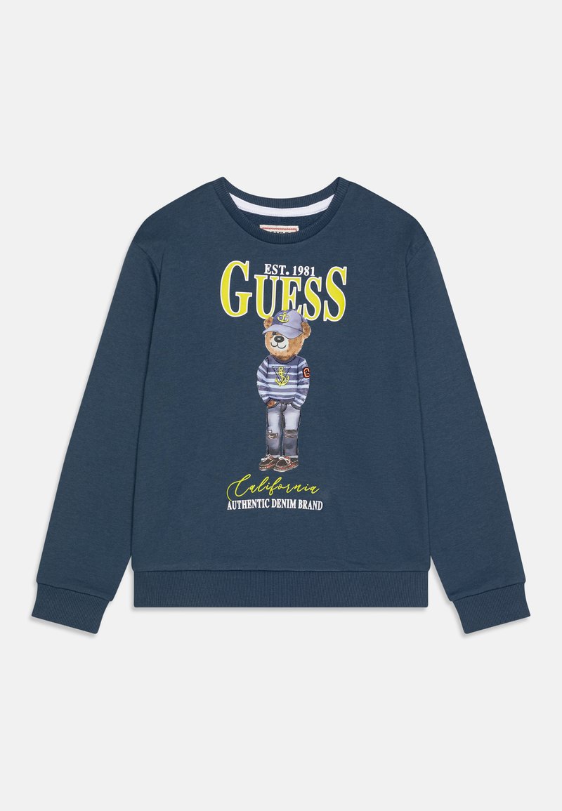 Felpa blu navy in cotone, con una grafica di un orso che indossa una camicia a righe e un cappello, con il testo "GUESS EST. 1981" in giallo.