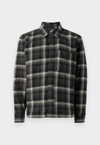 Camicia a quadri bianca e nera con colletto, maniche lunghe, chiusura a bottoni e taschino sul petto sinistro. Realizzata in un tessuto morbido e testurizzato.