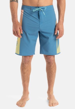 Bermudas de hombre azules con cintura de cordón, que presentan detalles en amarillo y rosa. Fabricadas con un material ligero y de textura suave.