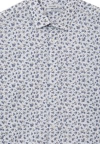 Weißes Hemd mit knöpfbarem Kragen in schmaler Passform, verziert mit einem floralen Muster in Marineblau und Beige. Weiches Material mit glatter Textur.