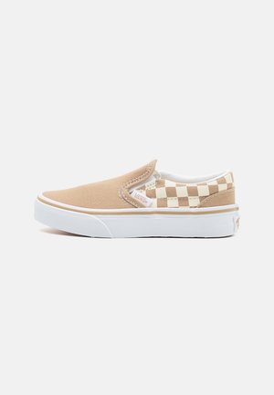Baskets slip-on beiges avec semelle blanche, présentant un motif à carreaux sur le talon, en toile et avec des accents cousus.