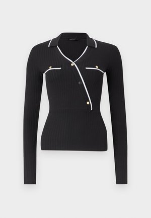 Μαύρο μακρυμάνικο ριμπ τοπ με λευκή επένδυση κατά μήκος του γιακά, διαγώνιο άνοιγμα με κουμπιά και ψεύτικες τσέπες με χρυσές λεπτομέρειες κουμπιών.