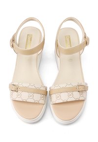 Sandali beige open-toe con cinturino alla caviglia regolabile, larga banda anteriore con motivo logo e suola bianca spessa.