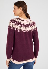 Maglione viola con un colletto decorato in crema, maniche lunghe e dettagli decorativi all'orlo. Tessuto morbido, vestibilità casual.