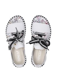 Witte geperforeerde schoenen met bloemaccenten, zwarte veters en gestreepte zwart-witte zool. Merkennaam "Venezia" zichtbaar aan binnenkant.