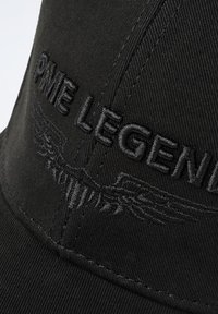 Casquette noire en tissu texturé avec "PME LEGEND" brodé en fil noir et un motif de détail en forme d'aile.