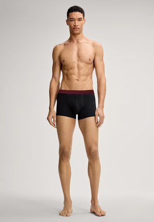Zwarte boxershort met een bordeauxrode elastische tailleband. Gemaakt van zachte, rekbare stof. Het ontwerp biedt een aansluitende pasvorm.