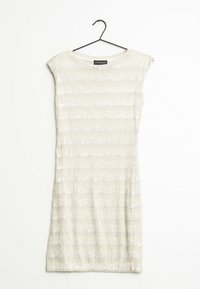 Robe courte sans manches en beige clair avec un motif texturé de rayures verticales, ornée de sequins pour un détail supplémentaire. Accrochée à un crochet noir.