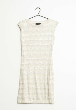 Krótka sukienka bez rękawów w jasnym beżu z teksturowanym wzorem pionowych pasków, ozdobiona cekinami dla dodatkowego efektu. Wisi na czarnym haczyku.