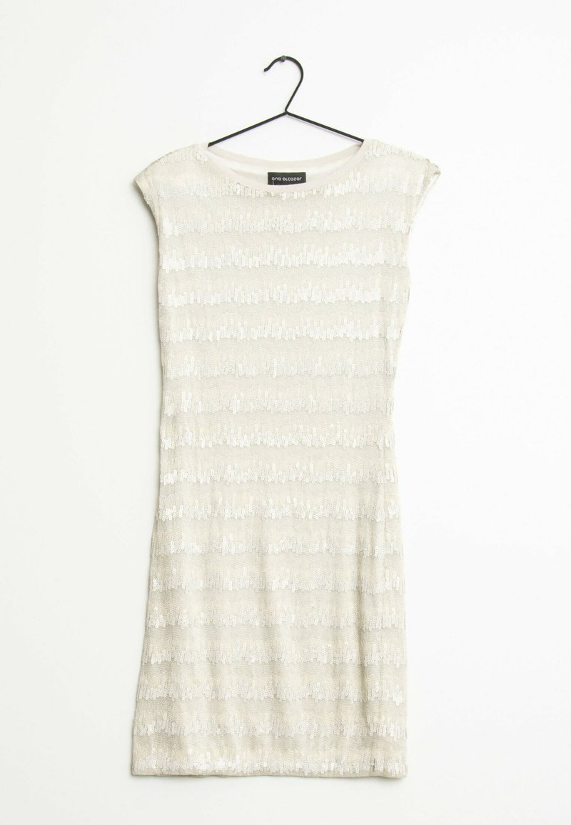 Short sleeveless dress in light beige with a textured pattern of vertical stripes, featuring sequins for added detail. Hangs on a black hook.