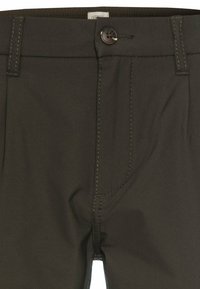 Dunkelgrüne Hose aus glattem Stoff, mit einem Knopfverschluss, sichtbaren Steppnähten und einem flachen Frontdesign mit Taschen.