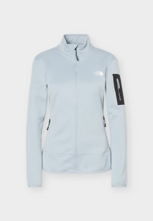 Ανοιχτό μπλε μπουφάν με πλήρη φερμουάρ και ψηλό γιακά, μαύρη τσέπη με φερμουάρ στο αριστερό μανίκι και λευκό λογότυπο The North Face στο στήθος.