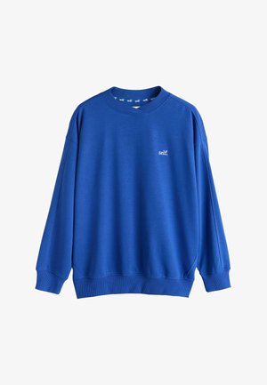 Blue long-sleeve crewneck sweatshirt with small white "self." text on the left chest and ribbed cuffs and hem.