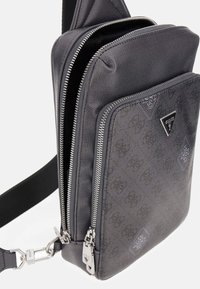 Borsa a tracolla grigia in materiale sintetico con due scomparti con zip, finiture testurizzate e dettagli in rilievo con il logo. Cinturino regolabile e hardware in metallo.