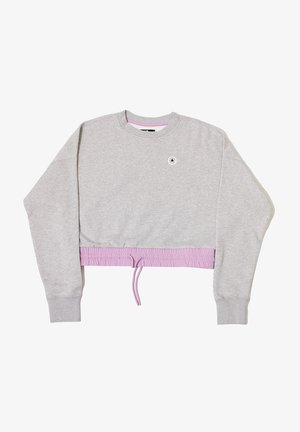 Sudadera corta gris con mangas largas, cinturilla elástica de color lavanda y un pequeño logo redondo cerca del escote. Material suave de mezcla de algodón.
