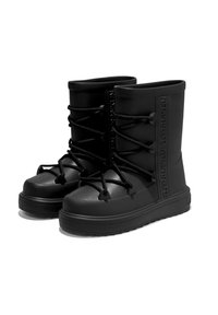 Botas de goma negras con la puntera redondeada, superficie texturizada y cordones negros. Presentan el nombre de la marca en relieve en el lateral y una suela gruesa.